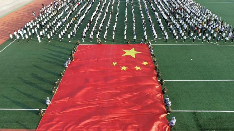 【青岛日报-观海新闻】师生齐托举，篮球场大小的巨幅国旗舞动雷竞技的赛事积分！